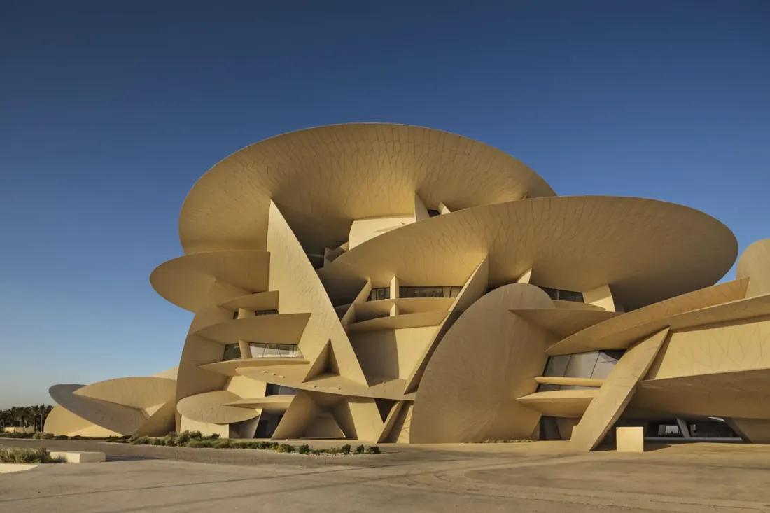 Desert-rose architecture of the National Museum of Qatar in Doha against a blue sky